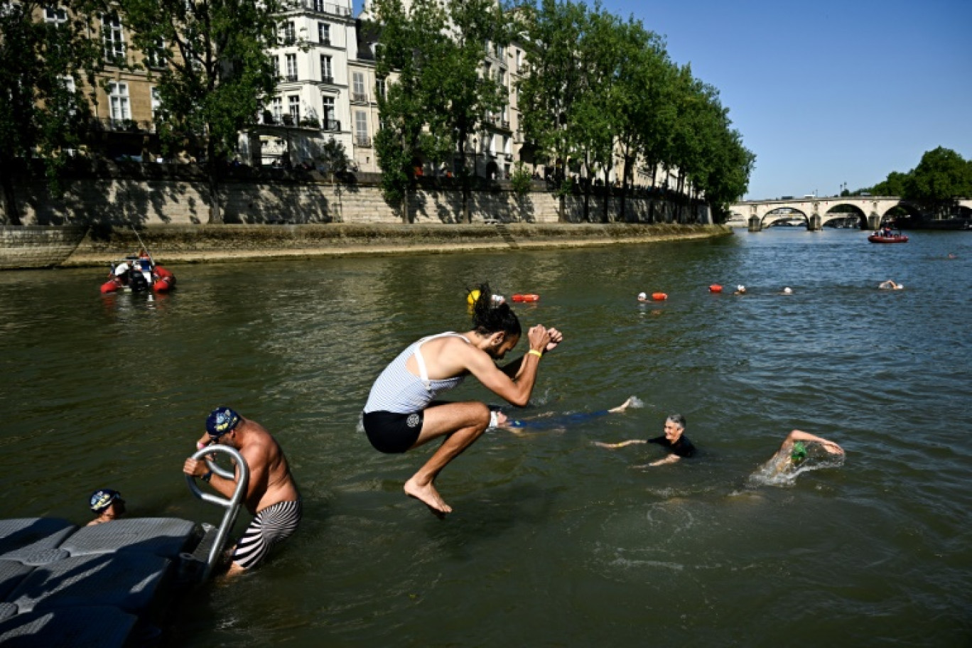 Une riveraine se jette à l'eau dans la Seine au bras Marie, le 17 juillet 2024 © JULIEN DE ROSA
