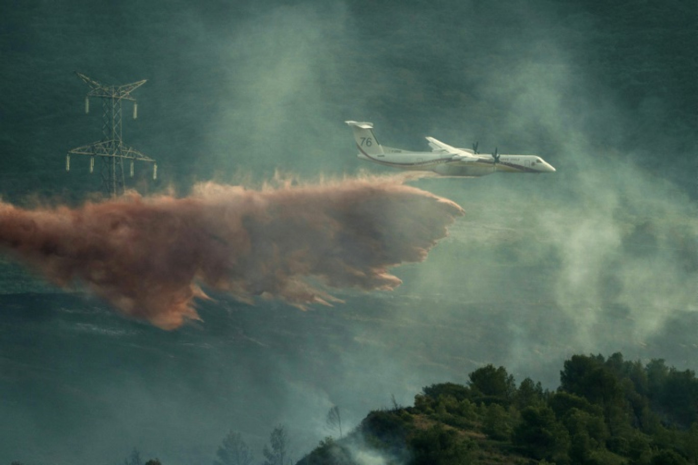 Un avion de lutte contre les incendies largue des produits ignifuges sur des arbres lors d'un incendie de forêt près de Fontcouverte, dans l'Aude, le 5 juillet 2025 © IDRISS BIGOU-GILLES