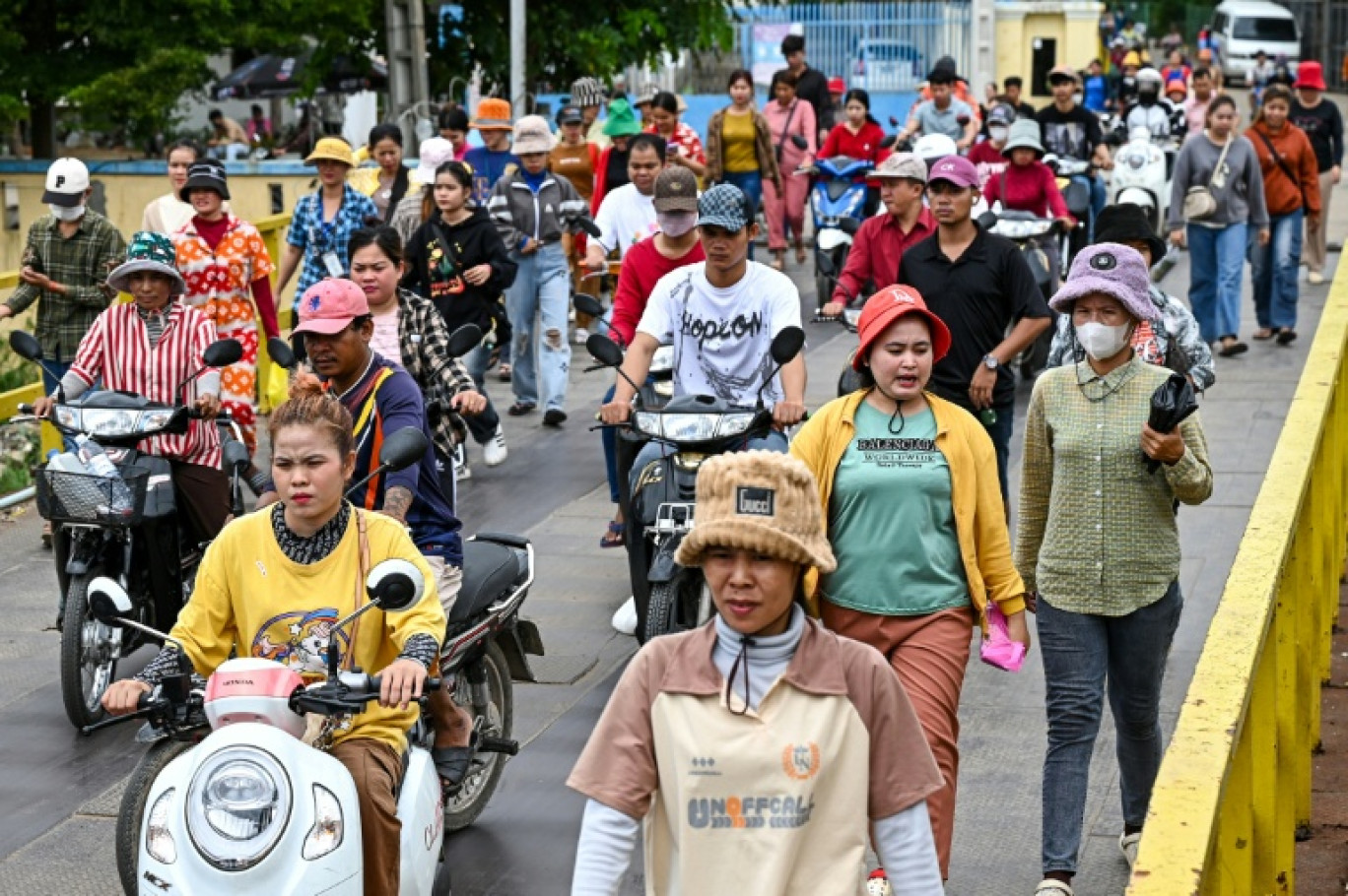 Des ouvriers de l'habillement sortent de leur usine pendant leur pause déjeuner à Phnom Penh, au Cambodge, le 8 juillet 2025. © TANG CHHIN Sothy