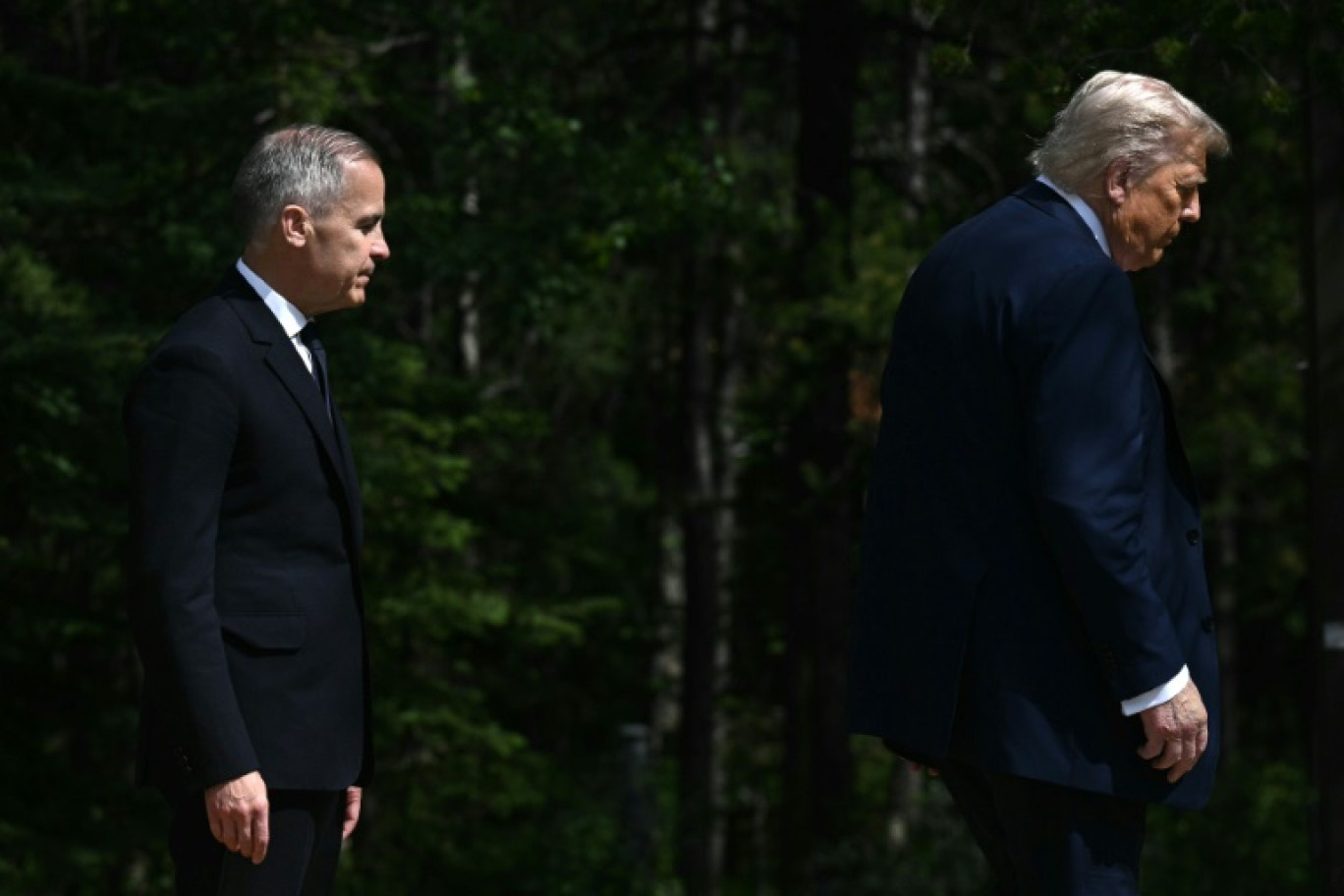 Le Premier ministre canadien Mark Carney (G) suit le président américain Donald Trump (D) lors du sommet du G7 à Kananaskis (Alberta), au Canada, le 16 juin 2025 © Brendan SMIALOWSKI