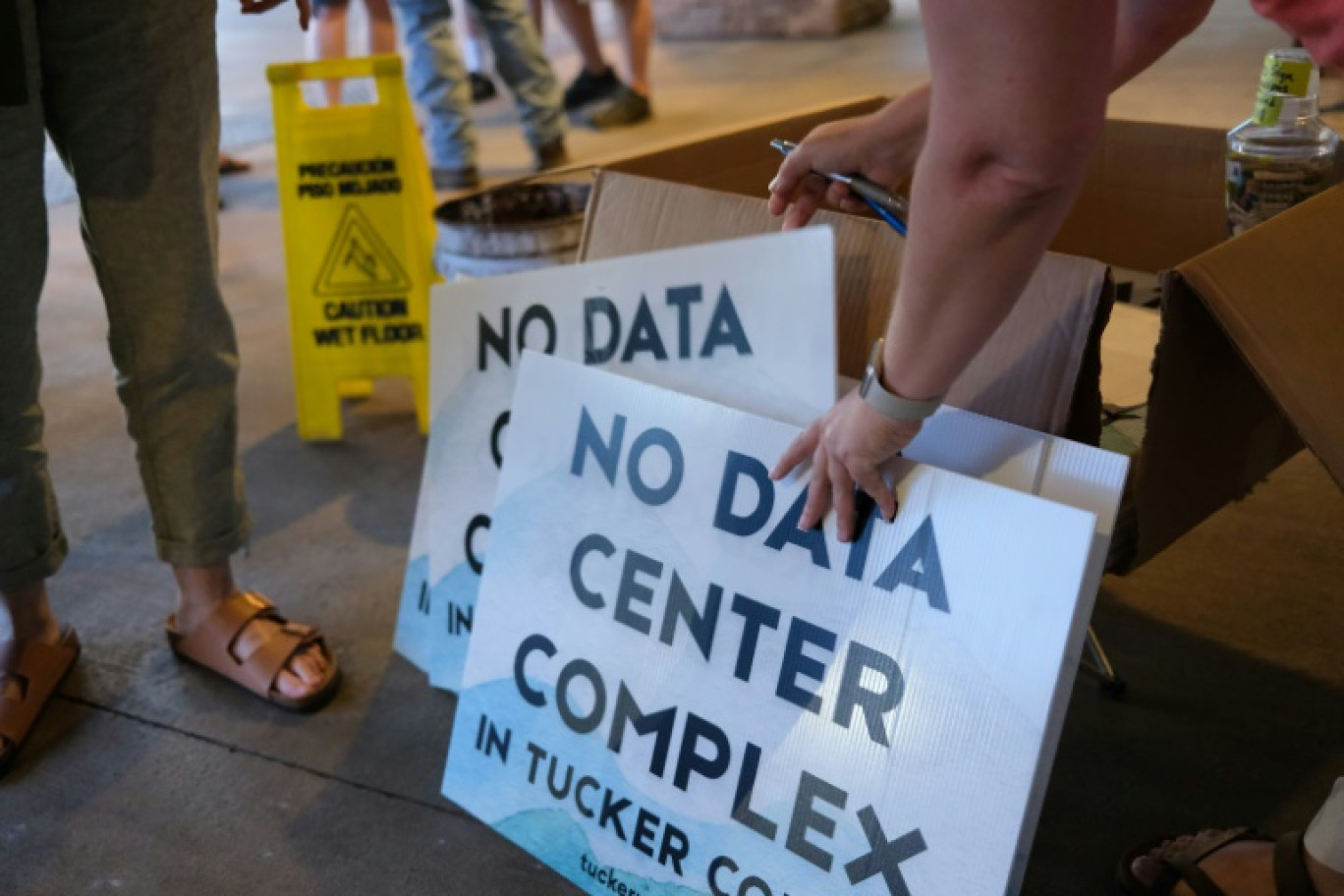 Des bénévoles distribuent des pancartes anti-data center en marge d'une réunion publique à Canaan Valley, en Virginie occidentale, le 30 juin 2025 © Ulysse BELLIER
