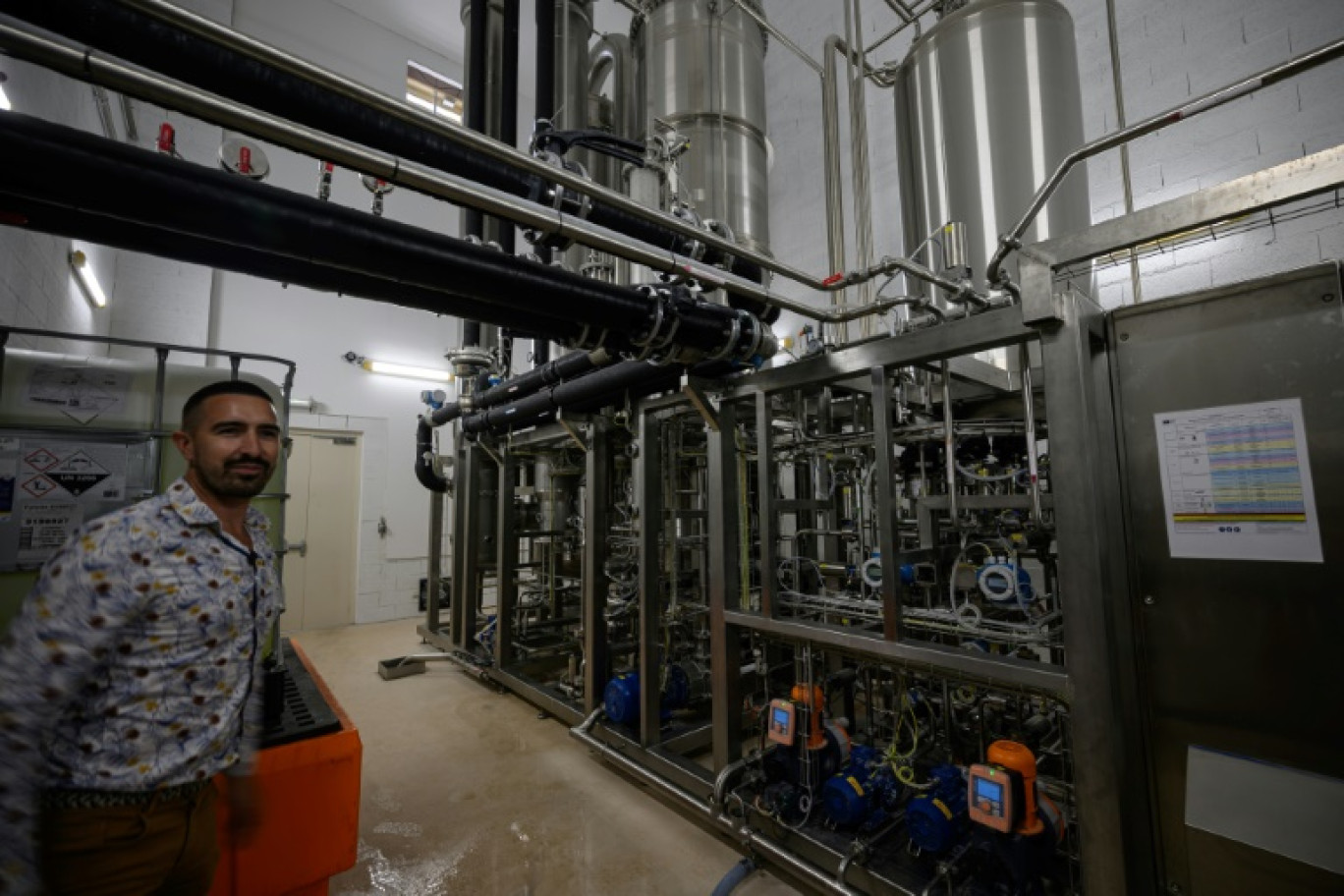 Un employé pose à côté d'une unité de désalcoolisation du vin dans le laboratoire du Chai sobre, le 25 juin 2025 à à Vic-Fezensac, dans le Gers © Lionel BONAVENTURE