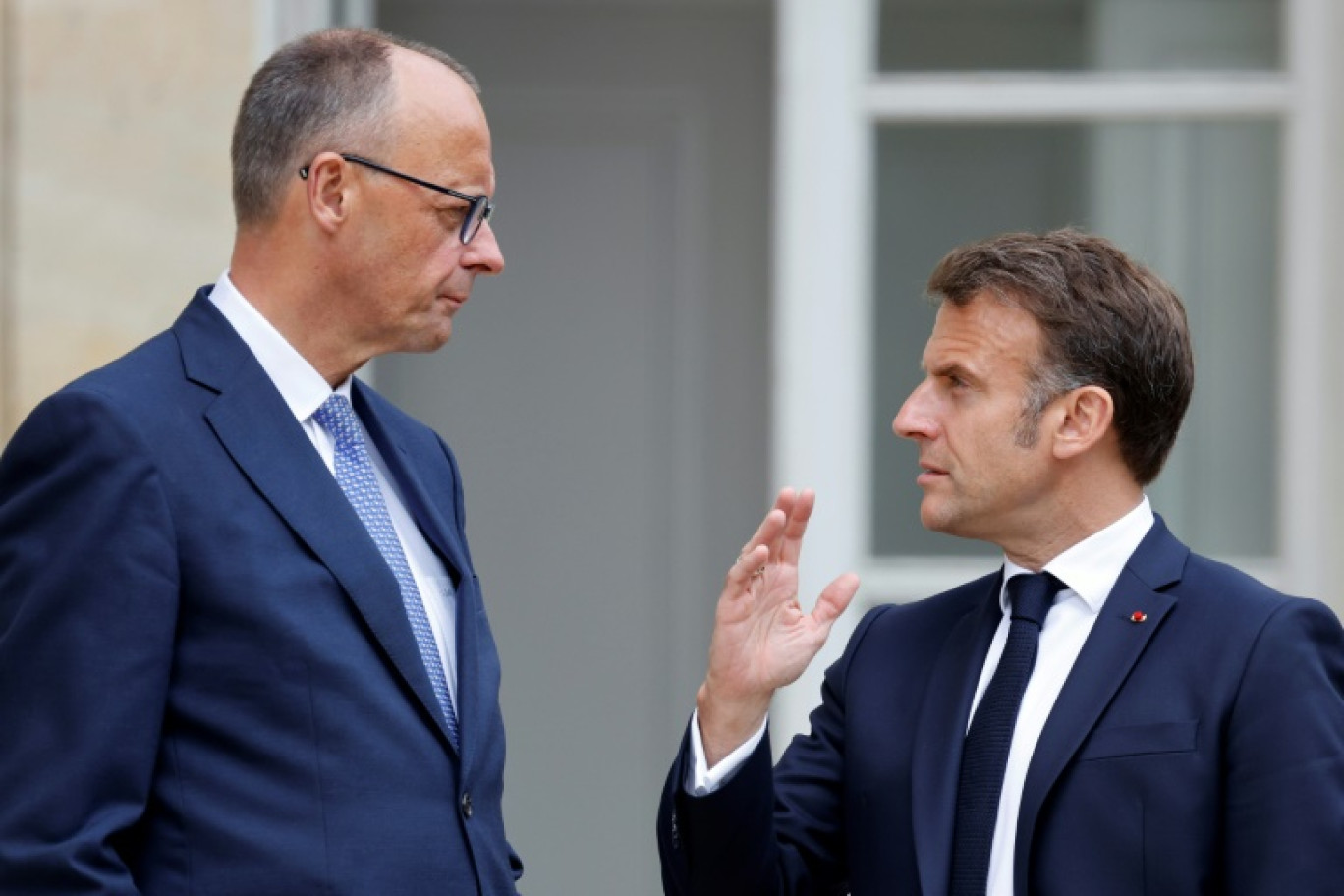 Le président français Emmanuel Macron (d) s'entretient avec le chancelier allemand Friedrich Merz dans le jardin du palais de l'Elysée à Paris, le 7 mai 2025 © Ludovic MARIN