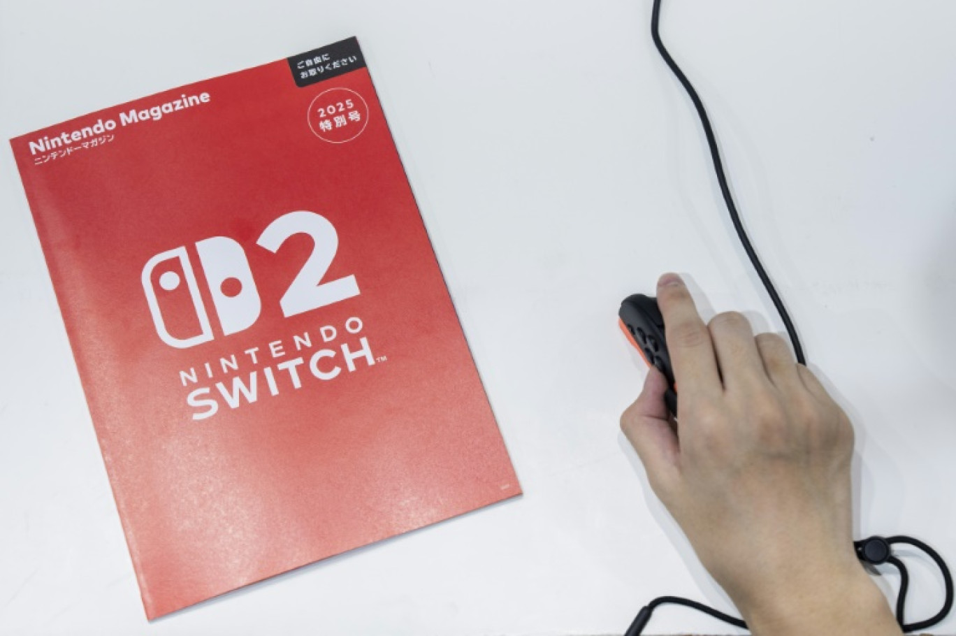 Un visiteur utilise la manette Joy-Con de la Nintendo Switch 2 en mode souris au salon BitSummit du jeu vidéo indépendant à Kyoto, le 18 juillet 2025 au Japon © Yuichi YAMAZAKI