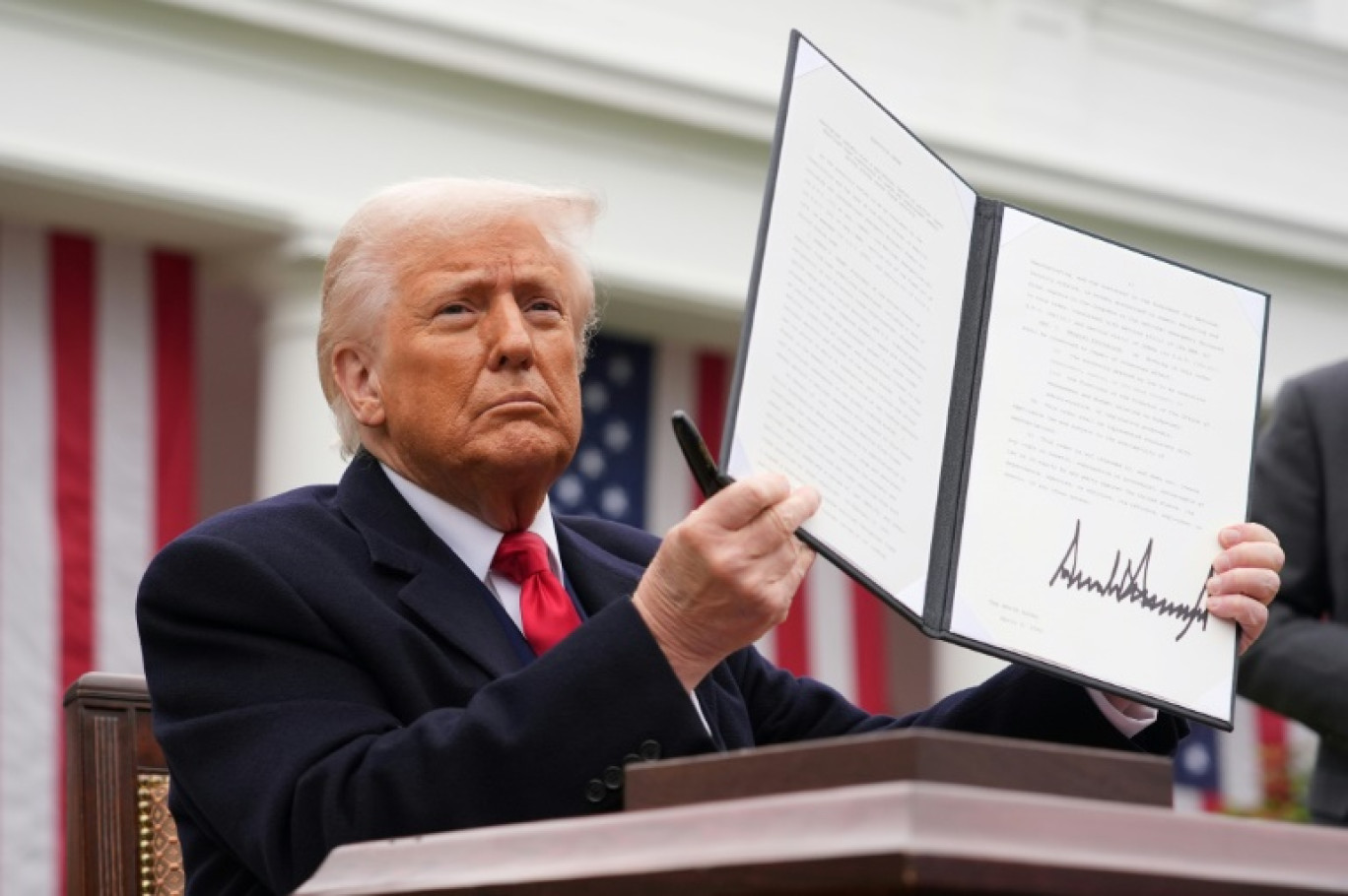Le président américain Donald Trump brandit un décret sur les droits de douane, le 2 avril 2025 à la Maison Blanche, à Washington © Andrew Harnik