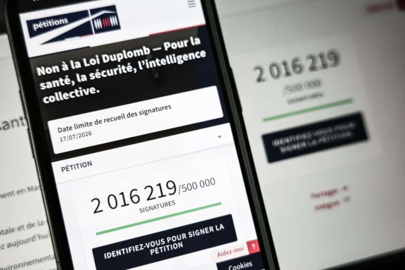 Le site de l'Assemblée nationale sur un écran de smartphone et d'ordinateur indiquant le nombre de citoyens ayant signé la pétition contre la loi Duplomb, le 28 juillet 2025 à Paris © Thibaud MORITZ