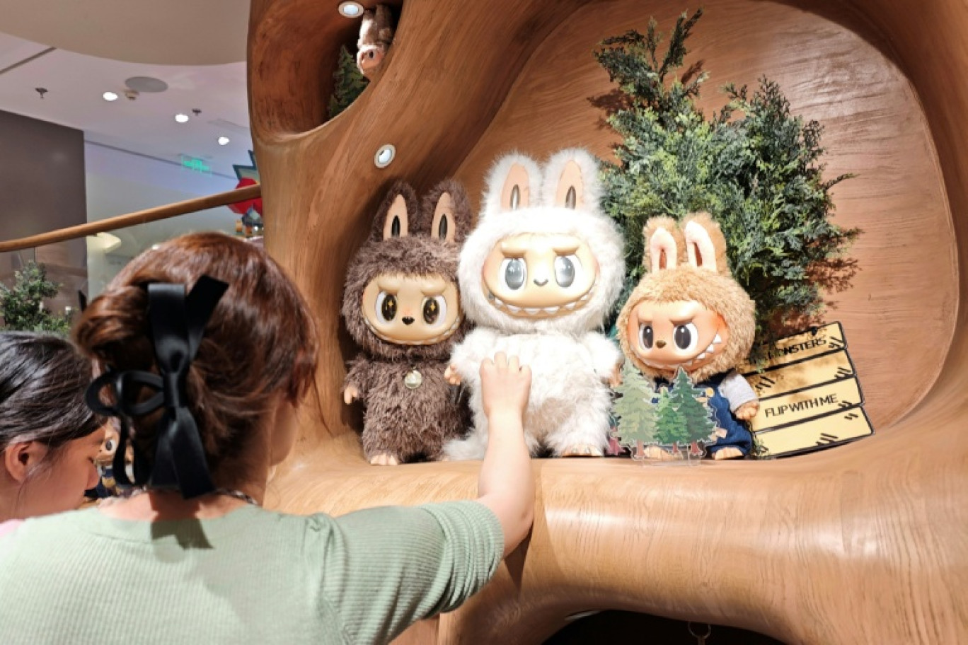 Des clients regardent des poupées Labubu dans un magasin Pop Mart à Shanghai, le 11 juin 2025 © STR