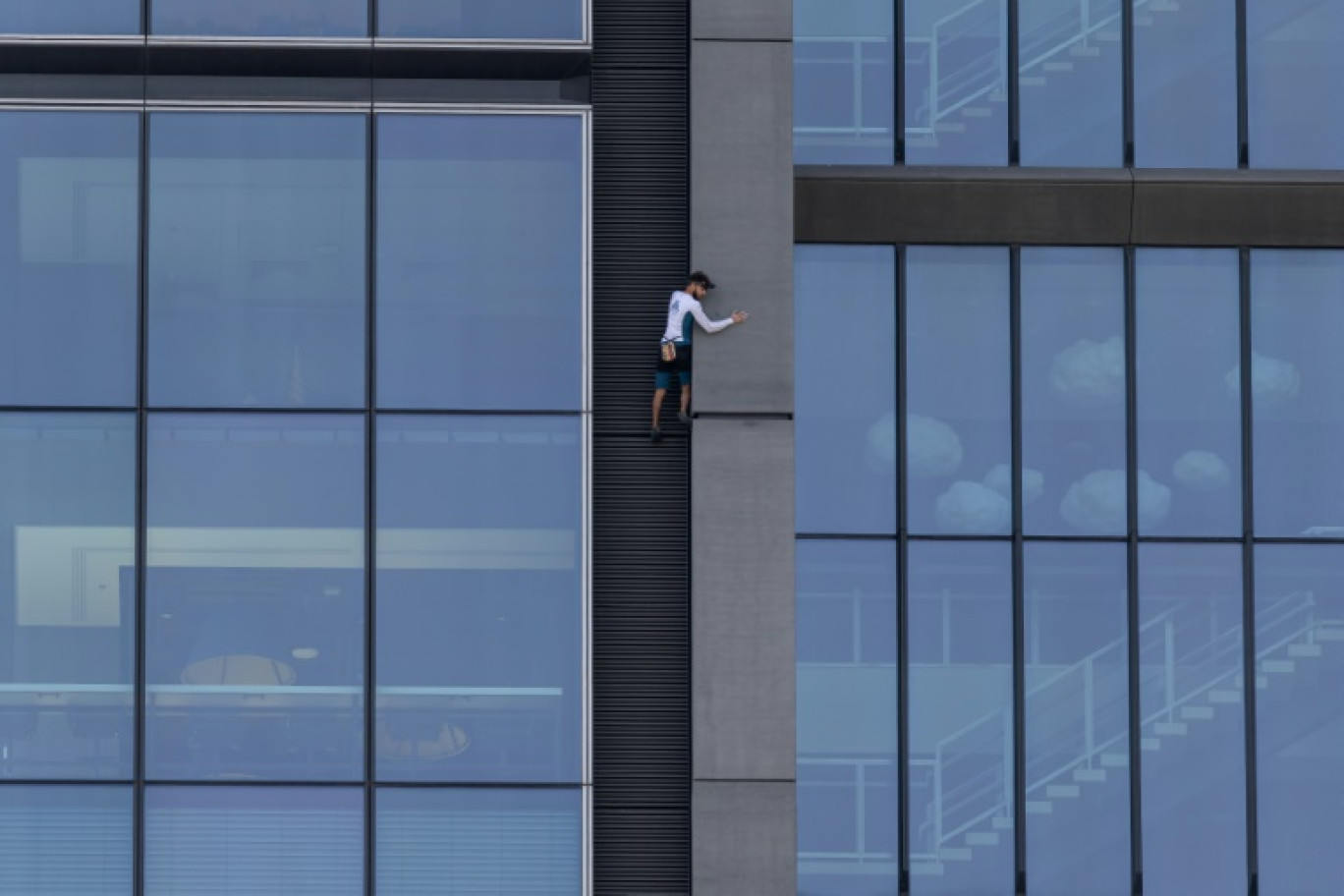 Le grimpeur français Titouan Leduc escalade à mains nues et sans protection la Varso Tower, le plus haut gratte-ciel de l'Union européenne, à Varsovie, le 27 septembre 2025 en Pologne © Wojtek RADWANSKI