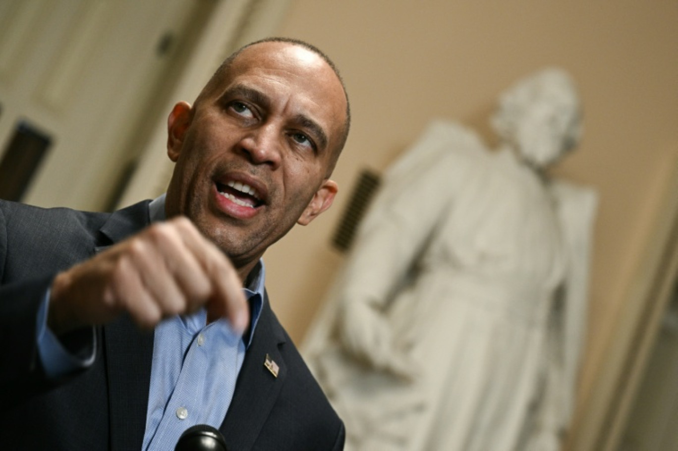 Le chef de la minorité démocrate à la Chambre américaine des représentants, Hakeem Jeffries, parle à la presse dans les couloirs du Capitole de Washington, le 24 septembre 2025 © Brendan SMIALOWSKI