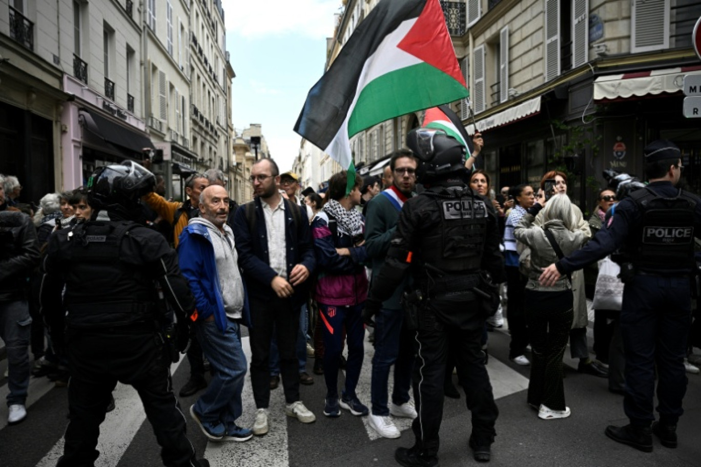 Le député La France Insoumise (LFI), Hadrien Clouet (c), des manifestants et des proches des militants français qui ont participé à la flottille pour Gaza  marchent vers l'Hôtel Matignon, lors d'un rassemblement à Paris, le 5 octobre 2025 © JULIEN DE ROSA