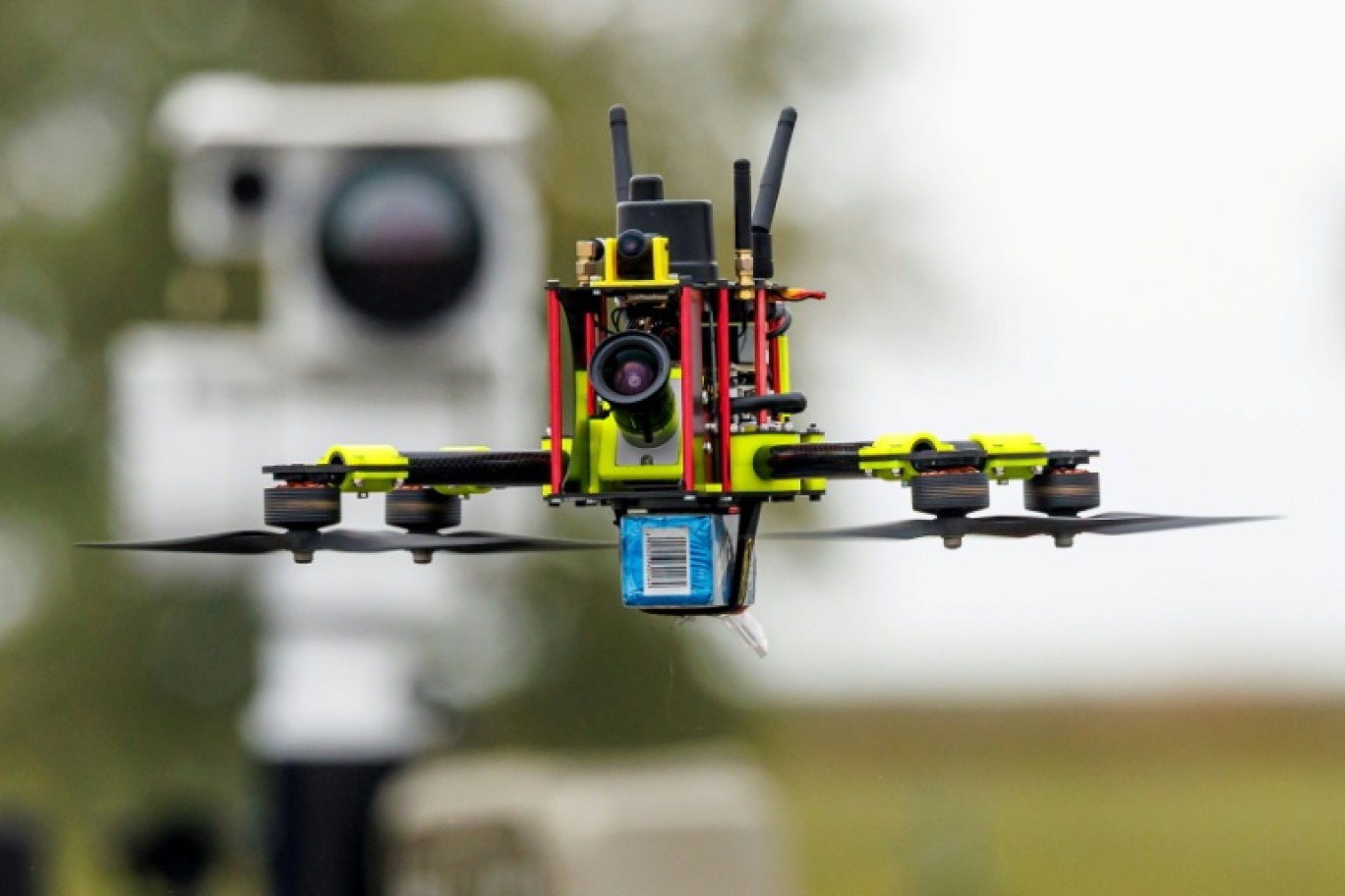 Un drone "chasseur" devant une unité de capteurs mobiles pour la détection de drones au Centre national de test pour les systèmes aériens sans pilote du Centre aérospatial allemand (DLR), lors d'une présentation du programme "Custodian" à Cochstedt, en Allemagne, le 8 octobre 2025 © JENS SCHLUETER