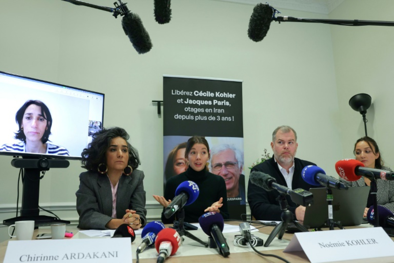 Anne-Laure Paris apparait sur un écran à gauche pendant une conférence de presse à laquelle participent, de gauche à droite, l'avocate Chirinne Ardakani, Noémie Kohler, l'avocat Martin Pradel et l'avocate Emma Villard à Paris le 16 octobre 2025 © Thomas SAMSON