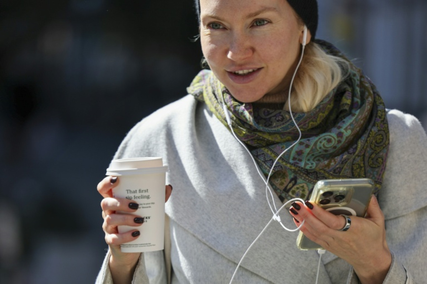 Une femme se déplace dans la rue avec son gobelet de café à New York, le 16 octobre 2025. © ANGELA WEISS