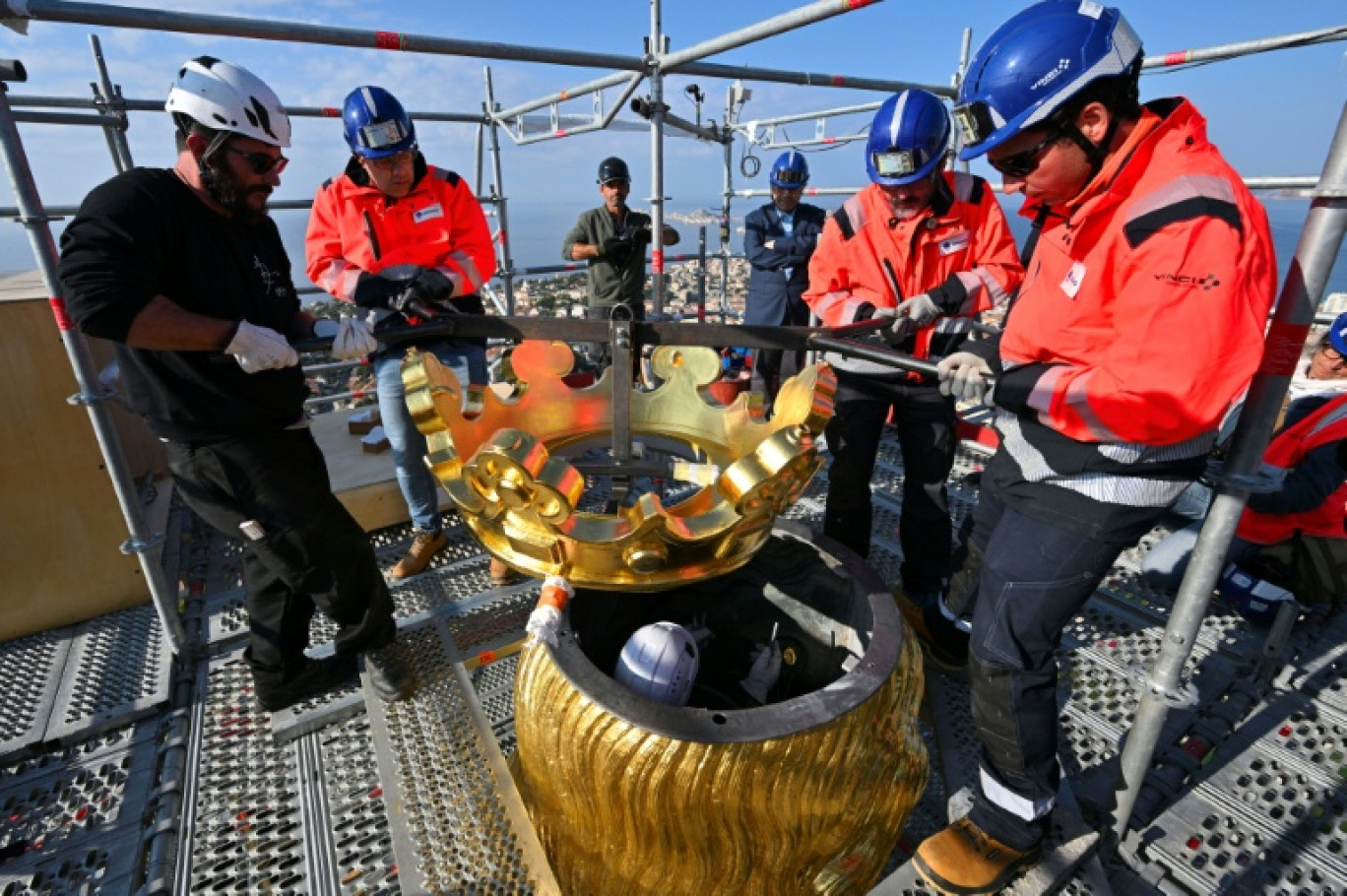 Des ouvriers remettent en place la couronne dorée de la statue de la Bonne Mère, à Marseille, le 17 octobre 2025 © Christophe SIMON
