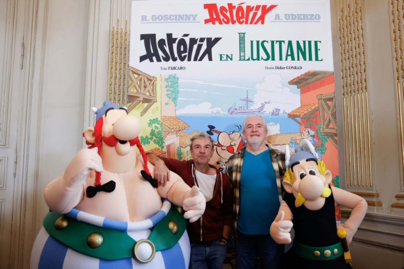 Les auteurs de la série Astérix et Obélix, Fabcaro (au centre à g.) et Didier Conrad (au centre à d.), posent entourés de personnes déguisées en Astérix (d) et Obélix (g), à l'ambassade du Portugal à Paris, le 13 octobre 2025 © Ian LANGSDON