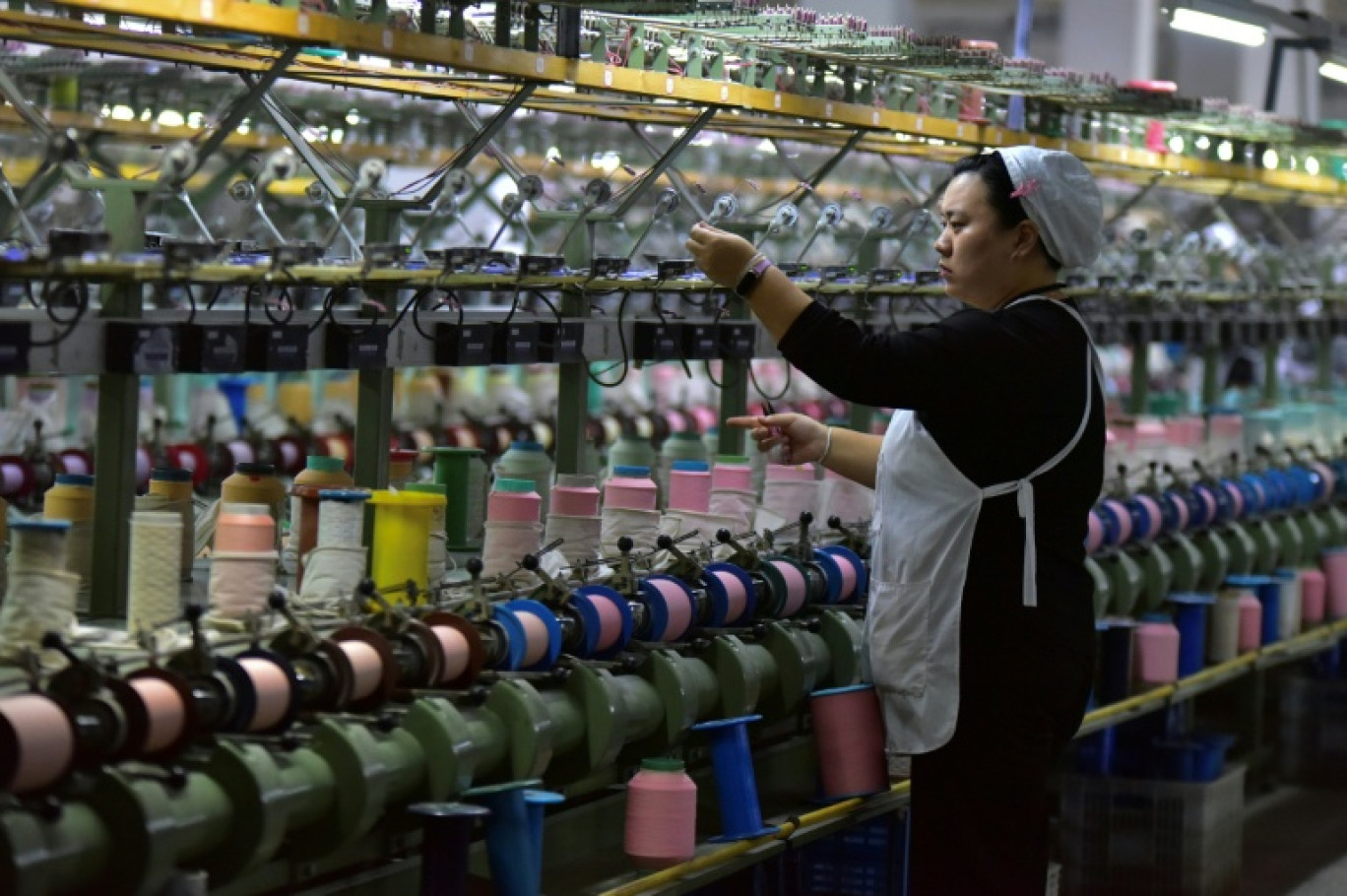Une ouvrière sur une chaîne de production de soie à Fuyang, dans la province de l'Anhui, dans l'est de la Chine, le 20 octobre 2025 © -STR