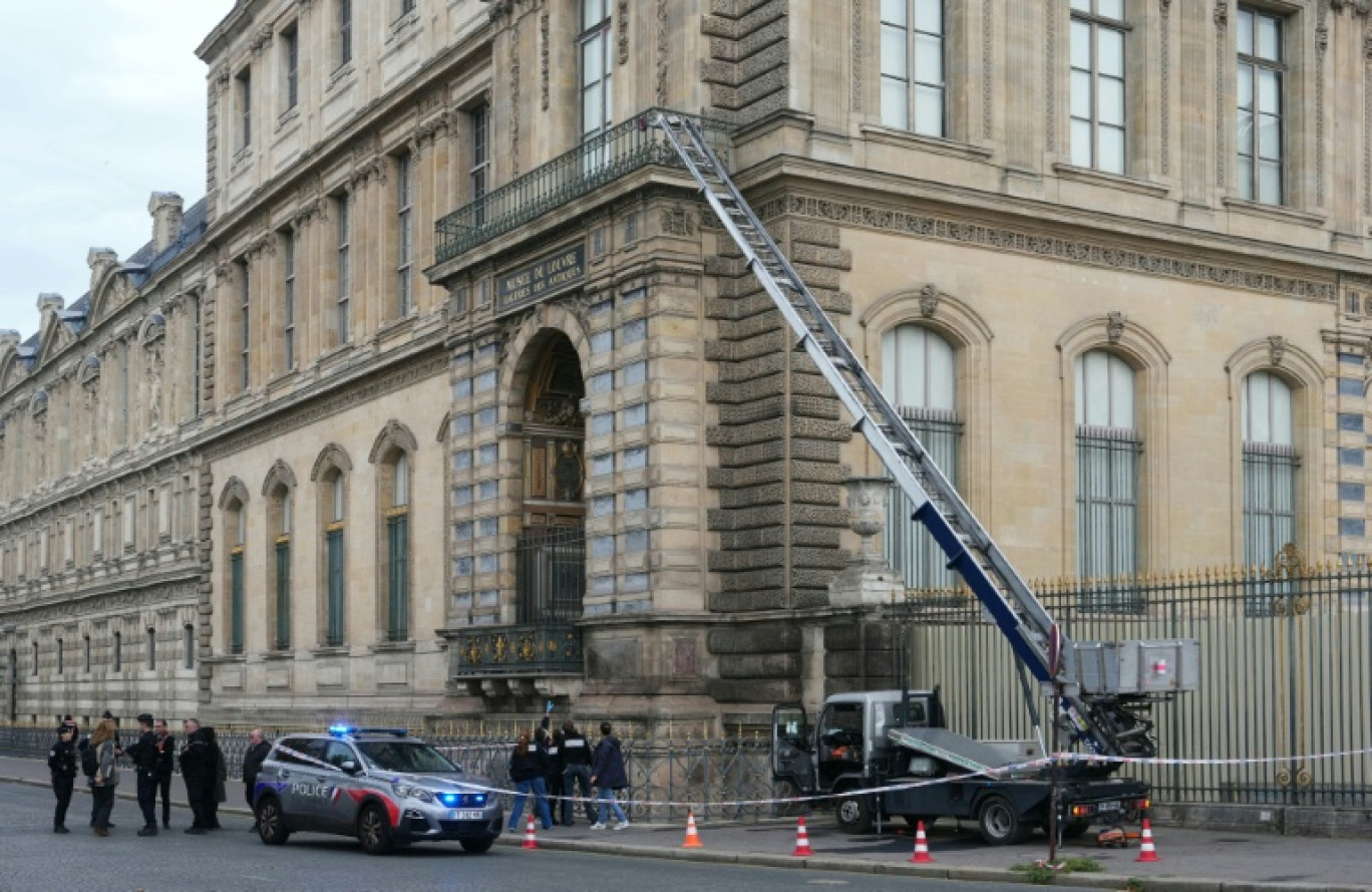 Des policiers à côté du monte-charge utilisé par des voleurs pour entrer dans le musée du Louvre, le 19 octobre 2025 © Dimitar DILKOFF