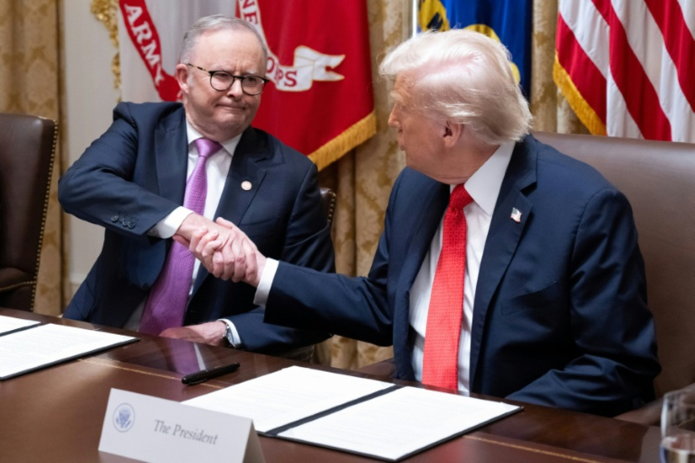 Le président américain Donald Trump (d) et le Premier ministre australien Anthony Albanese se serrent la main après la signature d'un accord sur les minéraux critiques à la Maison Blanche, le 20 octobre 2025 à Washington © SAUL LOEB