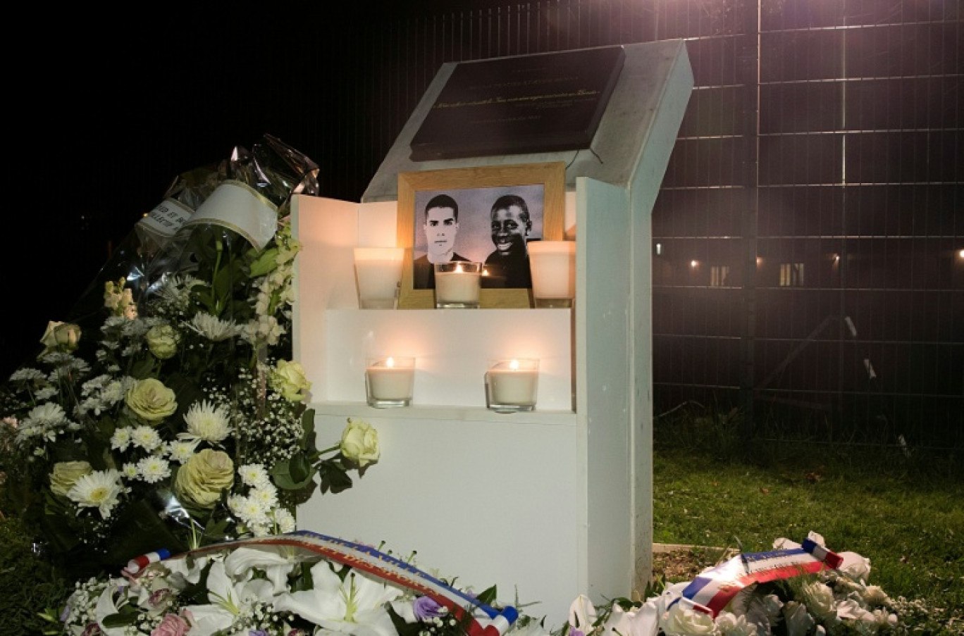 Des fleurs déposées près d'une plaque érigée à la mémoire de Bouna Traoré (d) et Zyed Benna, deux adolescents décédés en fuyant la police le 27 octobre 2005, à Clichy-sous-Bois, le 27 octobre 2015 en Seine-Saint-Denis © Joël SAGET