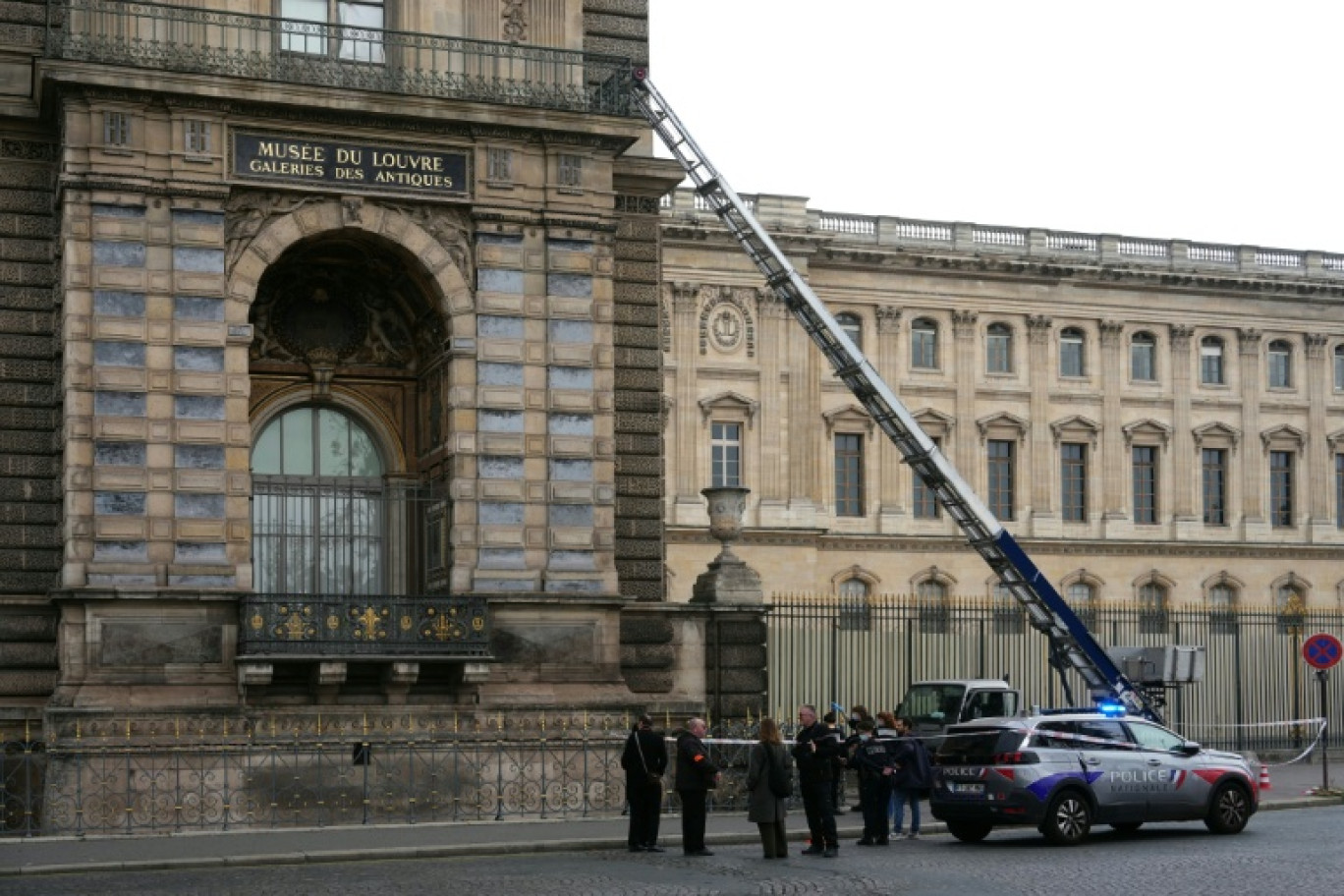 Des policiers français se tiennent à côté du monte-charge utilisé par des cambrioleurs pour pénétrer dans le musée du Louvre, sur le quai François Mitterrand, à Paris, le 19 octobre 2025 © Dimitar DILKOFF