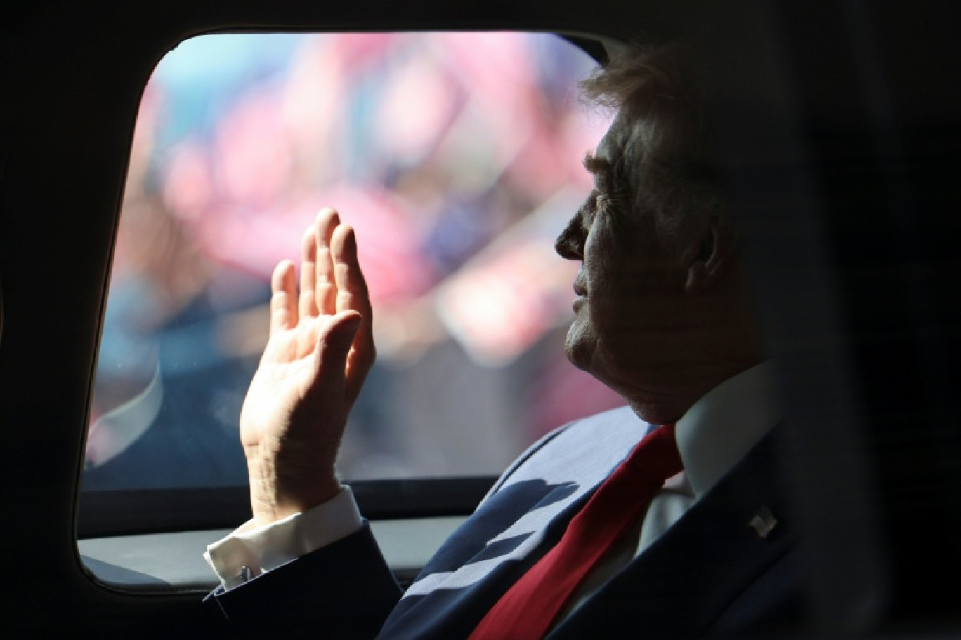 Le président américain Donald Trump effectue un salut de la main à bord de sa voiture, le 26 octobre 2025 à l'aéroport de Sepang en Malaisie © Hasnoor Hussain