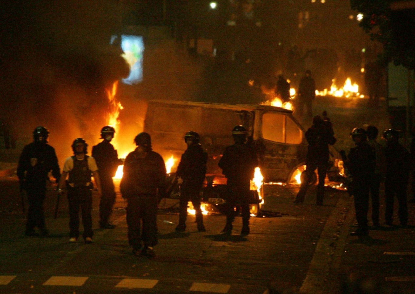 Des policiers devant des véhicules incendiés, le 28 octobre 2005 à Clichy-sous-Bois, en Seine-Saint-Denis, où de nouvelles violences urbaines ont éclaté entre des jeunes des quartiers difficiles et les forces de l'ordre © Joël SAGET