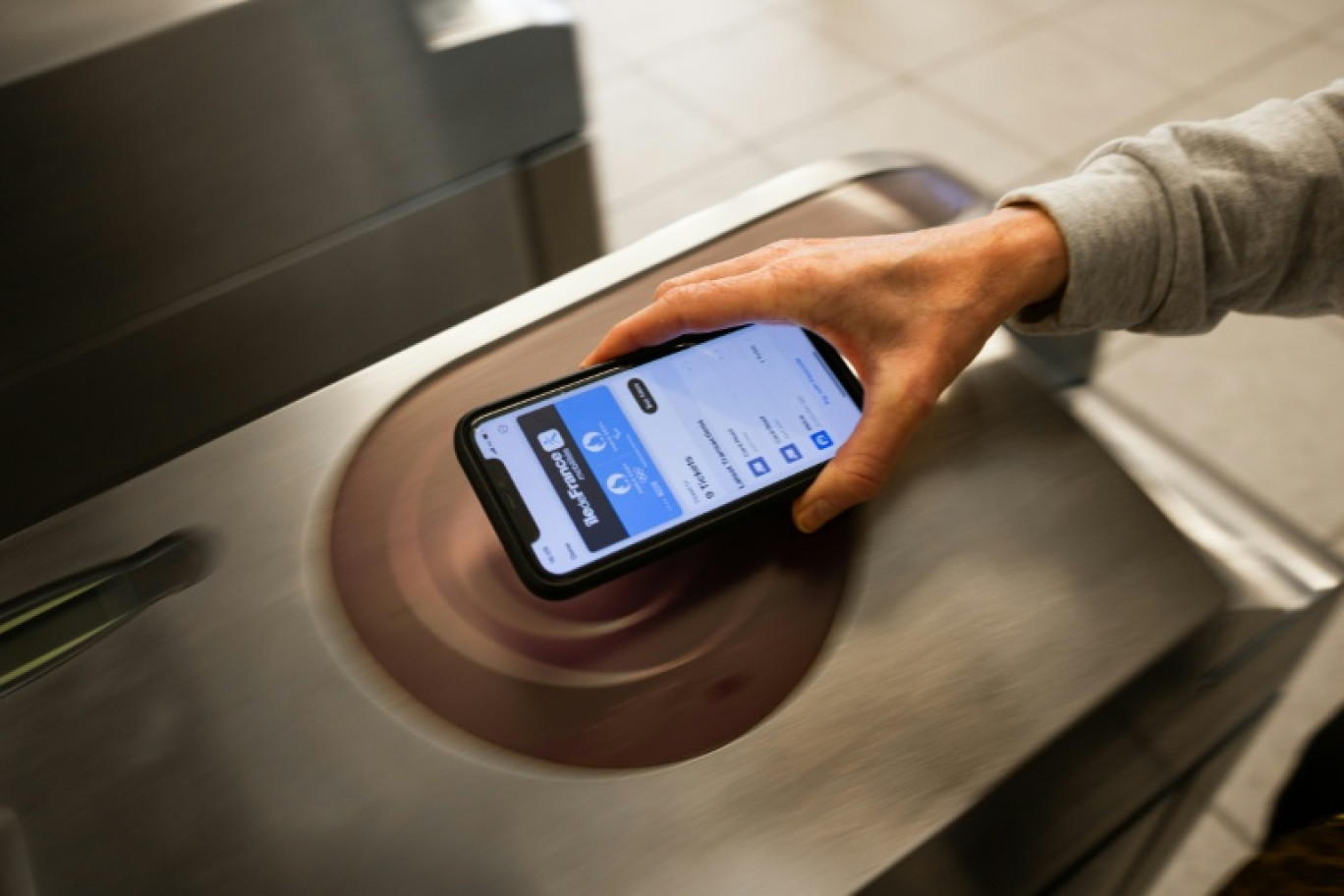 Utilisation d'un pass Navigo sur un iphone dans une station de métro à Paris, le 24 mai 2024. © Antonin UTZ