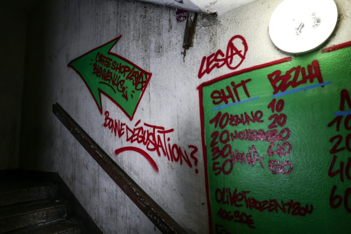 Des tarifs de stupéfiants peints sur le mur d'une cage d'escalier de la Cité des Olivier à Marseille, le 9 décembre 2025 © Thibaud MORITZ