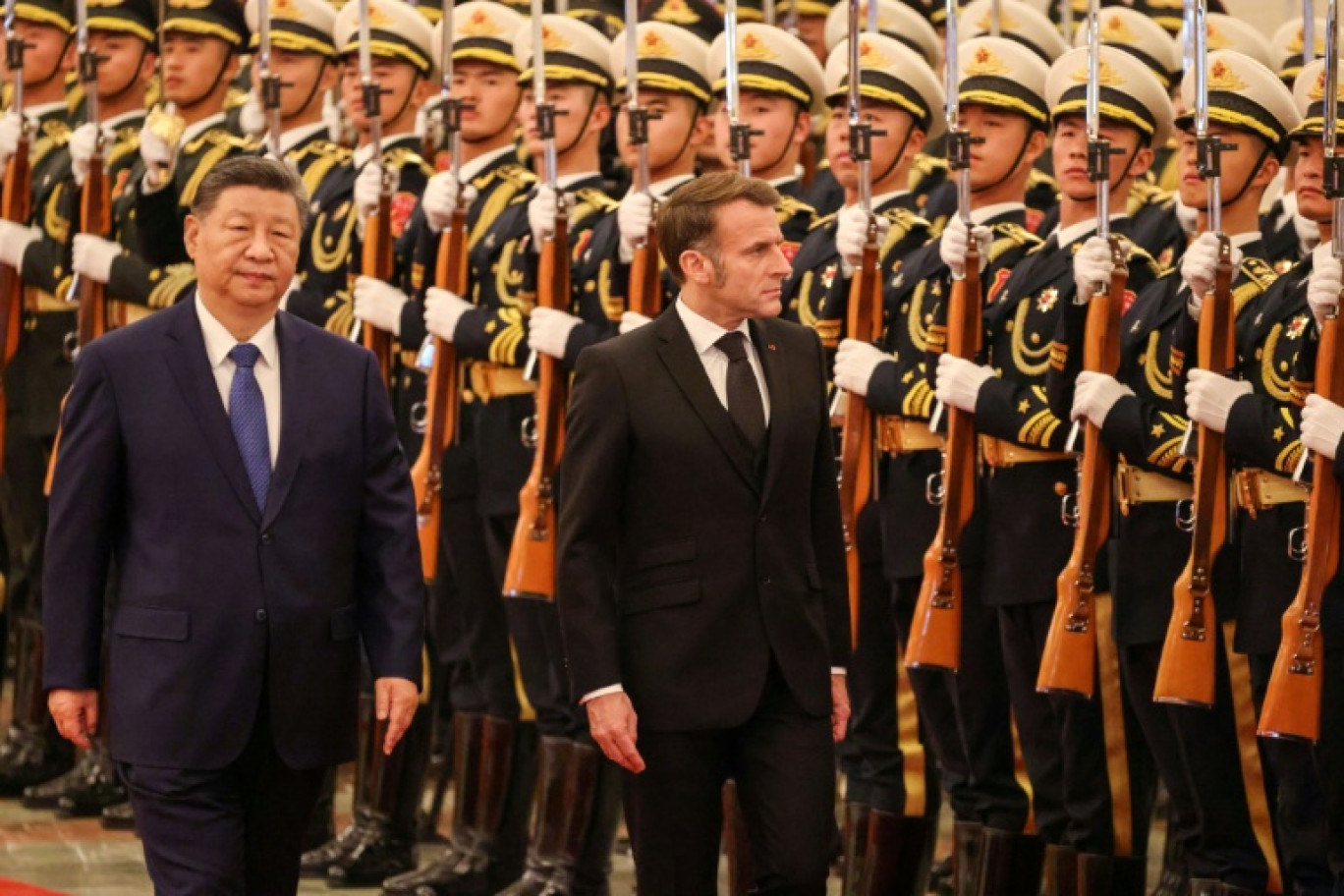 Le président chinois Xi Jinping (à gauche) et le président français Emmanuel Macron (à droite) passent en revue la garde d'honneur lors d'une cérémonie de bienvenue au Palais du Peuple à Pékin, le 4 décembre 2025 © Ludovic MARIN