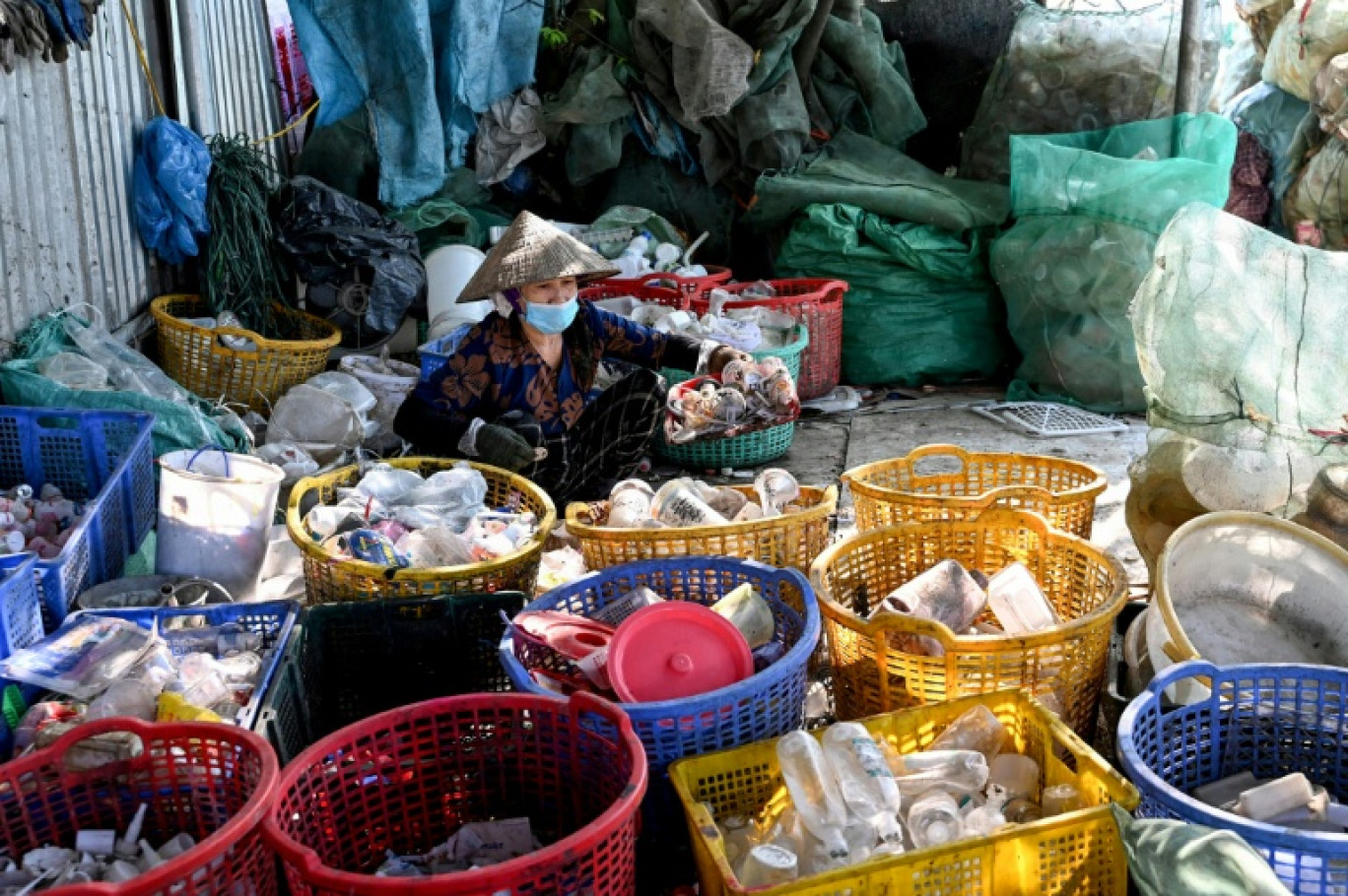 Une femme trie des déchets n plastique près de Hanoï, au Vietnam, le 25 novembre 2025 © Nhac NGUYEN