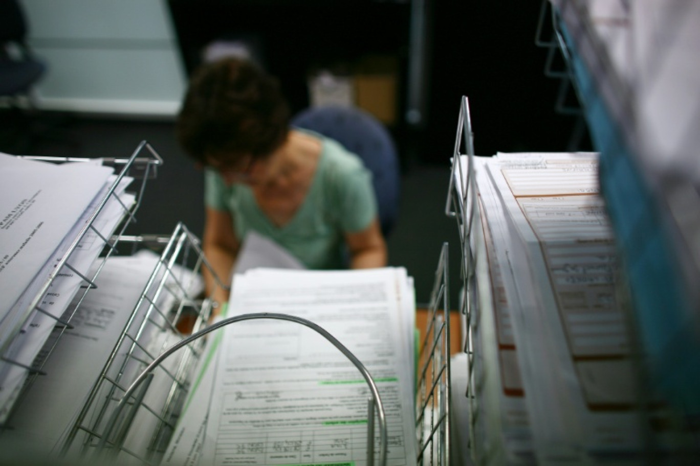 Une personne classe des feuilles de soin à la Caisse Primaire d'Assurance Maladie (CPAM) de Lyon, alors que l'Assemblée nationale vote mardi sur le Projet de loi de finance de la Sécurité sociale (PLFSS) © FRED DUFOUR
