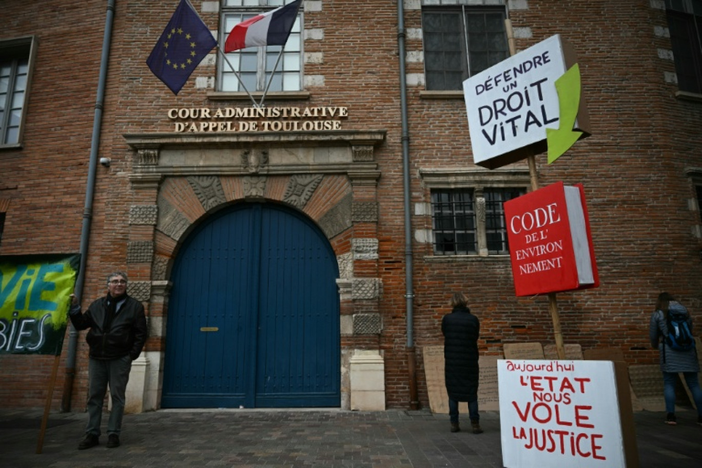 Un homme brandit une pancarte lors d’une manifestation contre le projet d’autoroute A69, devant la cour administrative d’appel à Toulouse, le 11 décembre 2025 © Lionel BONAVENTURE