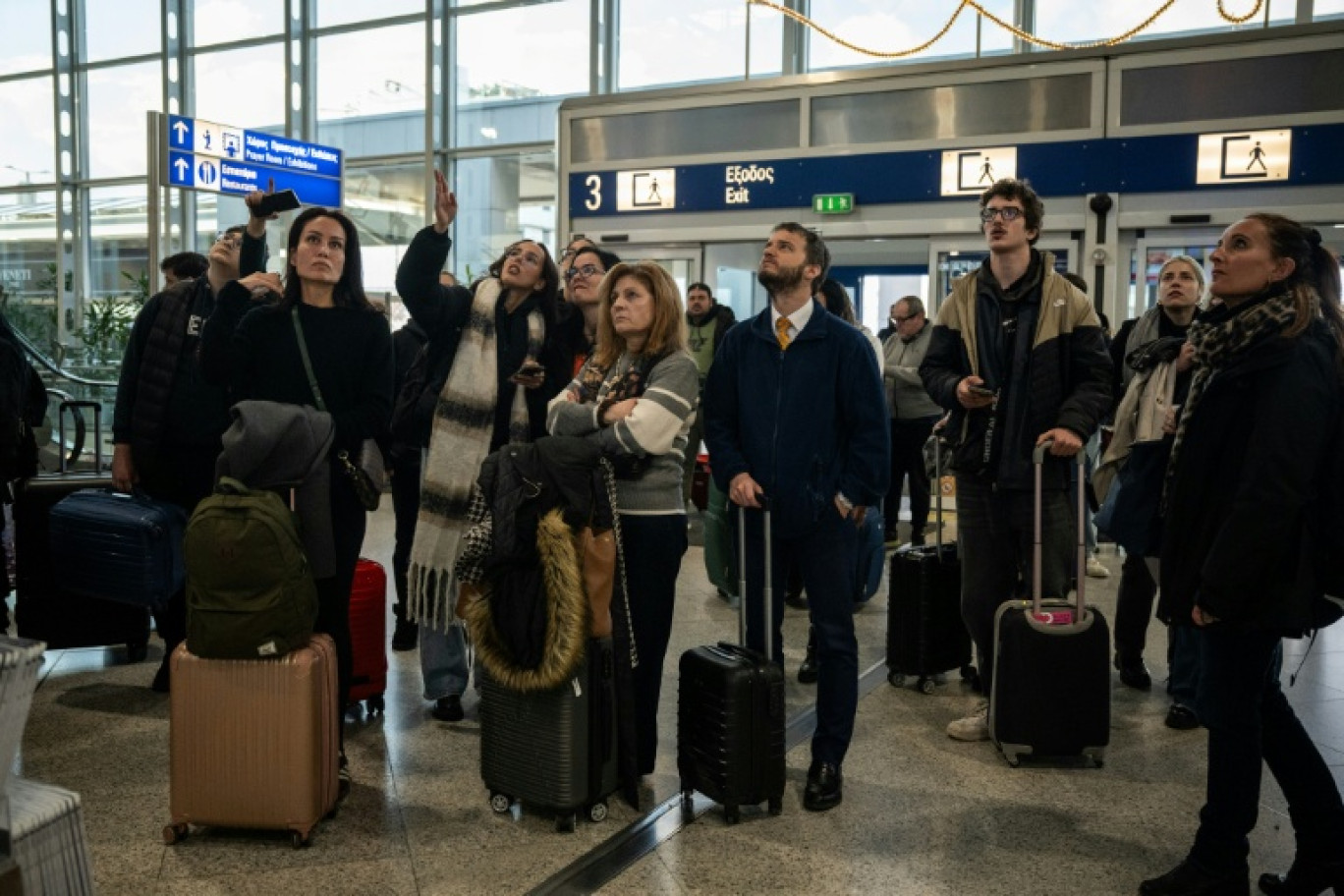 Des voyageurs attendent à l'aéroport d'Athènes-Spata après des retards et des reports de vols dans le pays dus à un "problème technique", le 4 janvier 2026 © Angelos TZORTZINIS