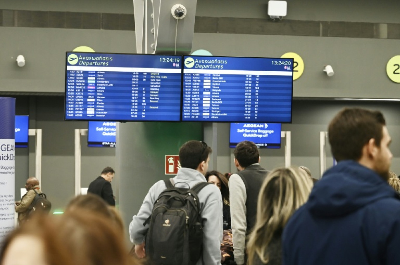 Des passagers devant un panneau d'information affichant de nombreux vols annulés, à l'aéroport de Thessalonique en Grèce le 4 janvier 2026 © Sakis Mitrolidis