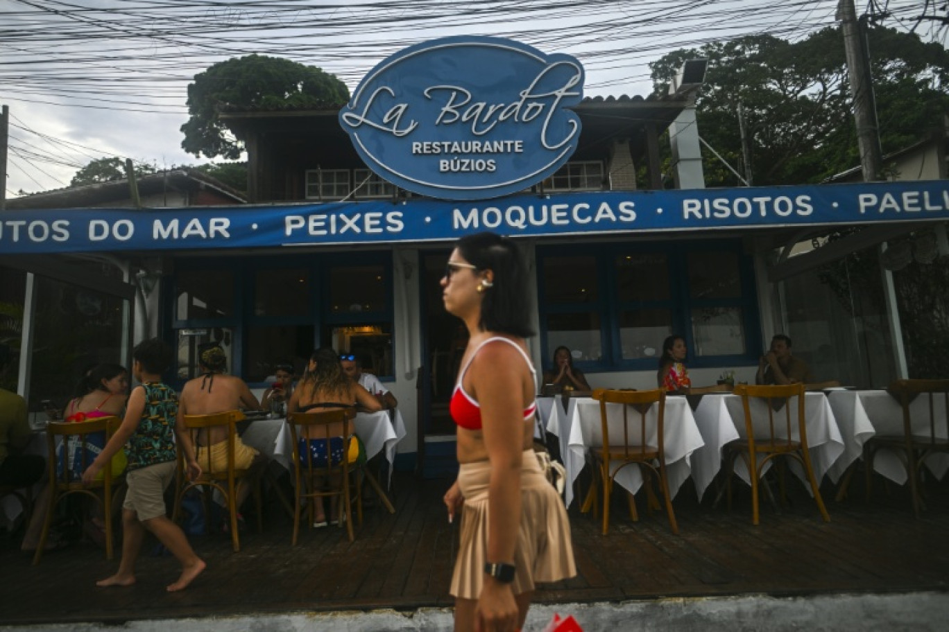 Une femme passe devant le restaurant Le Bardot à Buzios, au Brésil, le 3 janvier 2026 © MAURO PIMENTEL