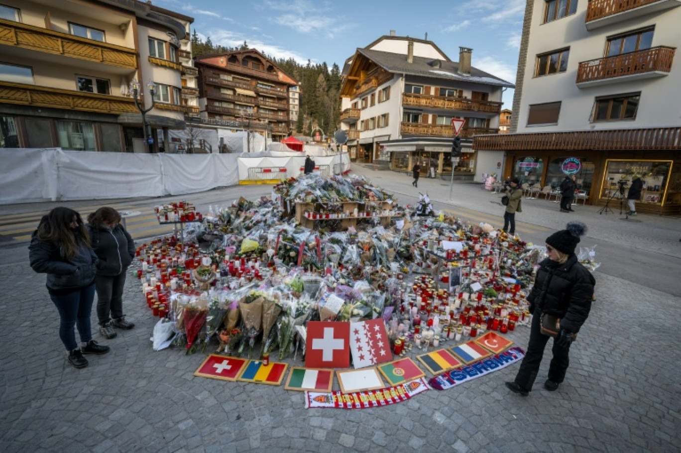 Des fleurs, des messages et des drapeaux déposés sur un mémorial improvisé le 6 janvier 2026 en hommage aux victimes de l'incendie mortel d'un bar dans la nuit du nouvel an à Crans-Montana, en Suisse © Fabrice COFFRINI