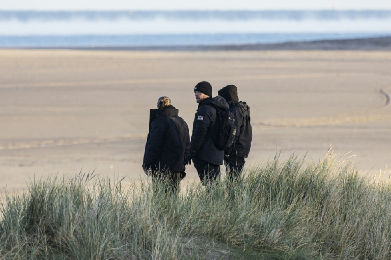 Des militants d'extrême droite britanniques surveillent la plage de Gravelines, pour empêcher des migrants de traverser la Manche, le 5 décembre 2025 dans le nord de la France © Sameer Al-DOUMY