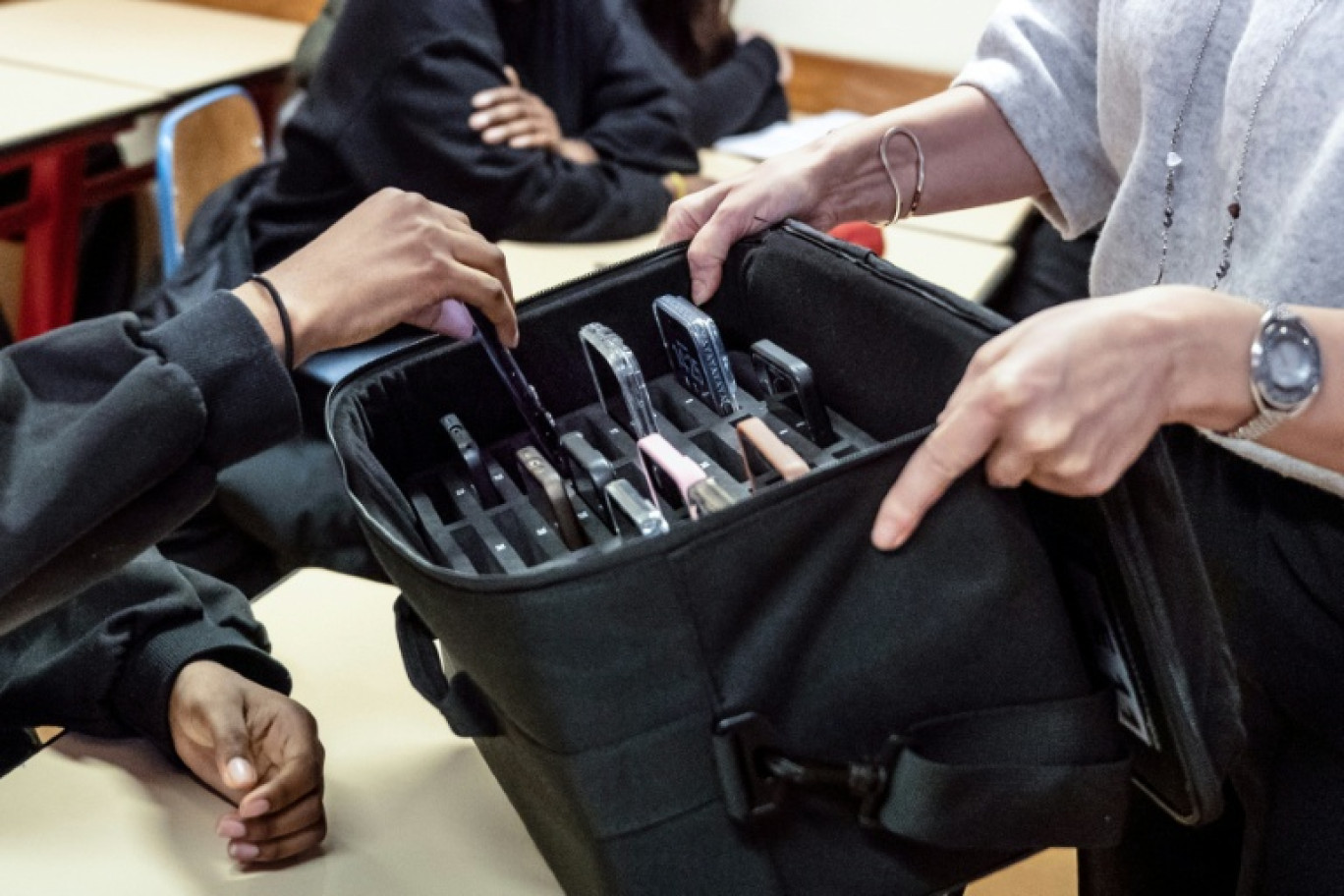 Une enseignante récupère les téléphones portables des élèves, mis de côté pendant les cours au lycée professionnel Jean Mermoz de Montsoult, le 14 janvier 2026 dans le Val-d'Oise © BERTRAND GUAY