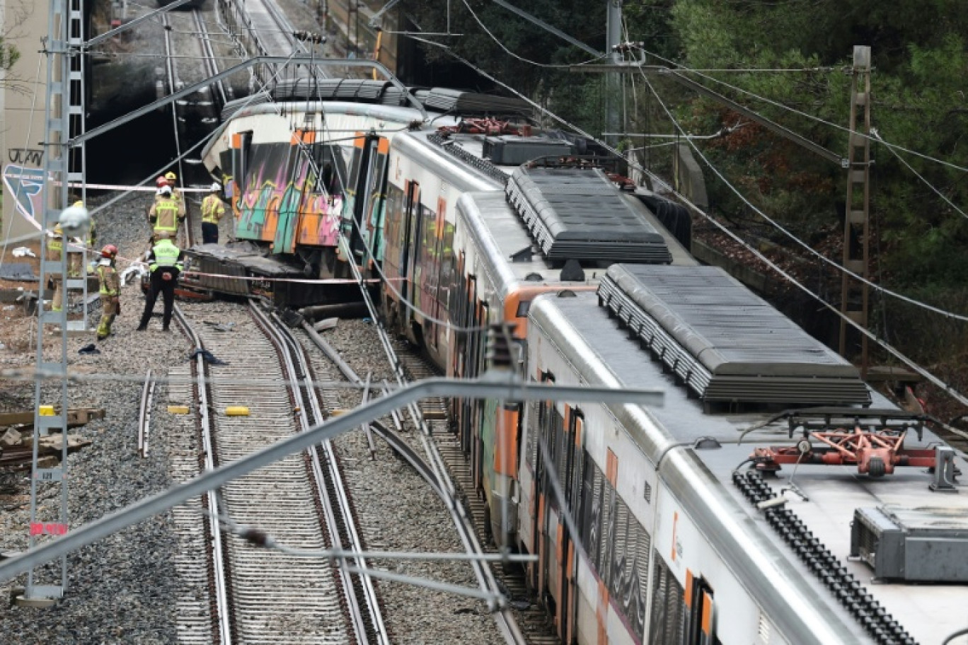 Des pompiers sur le site où un train régional est entré en collision avec un mur effondré entre Sant Sadurni d'Anoia et Gelida, près de Barcelone, le 21 janvier 2026 en Espagne © Josep LAGO