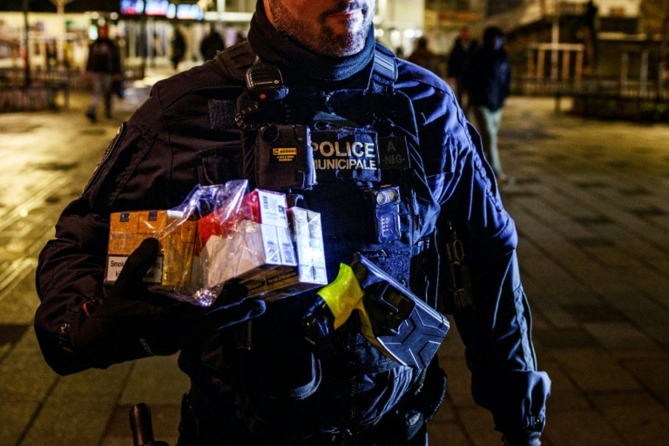 Un policier municipal avec des cartouches de cigarettes de contrebande saisies à Saint-Denis, en Seine-Saint-Denis, le 22 janvier 2026 © Dimitar DILKOFF