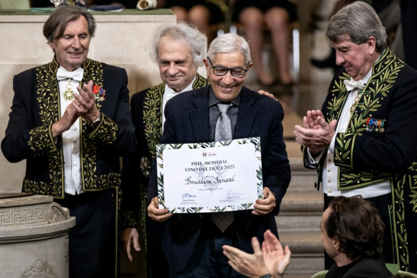 L'écrivain franco-algérien Boualem Sansal (c), entouré par les membres de l'Académie français, Daniel Rondeau (g), Amin Maalouf (c,g) et Xavier Darcos (d), reçoit le prix Cino del Duca à l'Académie française, à Paris, le 4 décembre 2025 © BERTRAND GUAY