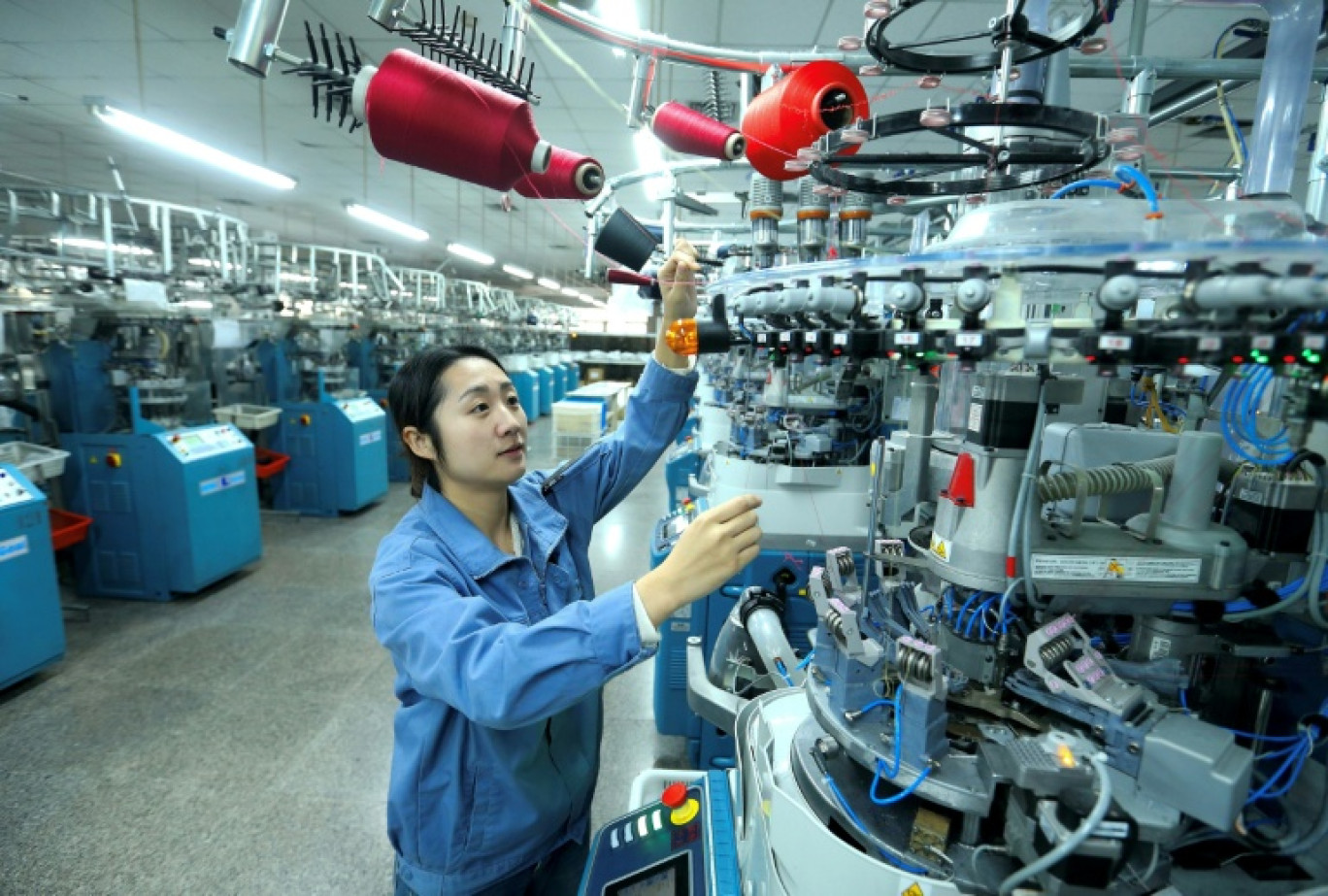 Un ouvrier utilise une machine dans une usine textile à Qingdao, dans la province du Shandong, dans l'est de la Chine, le 15 décembre 2025 © -