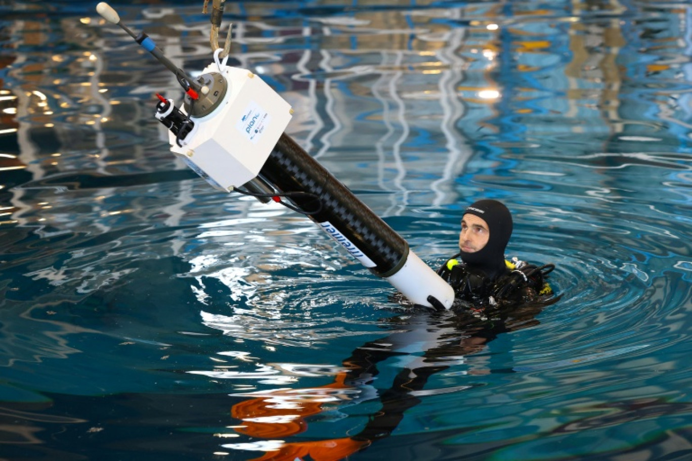 Un technicien en combinaison de plongée manipule un flotteur Argo au centre de contrôle Ifremer pour le calcul et les données en mer à Plouzané, le 15 octobre 2025 dans le Finistère © Fred TANNEAU