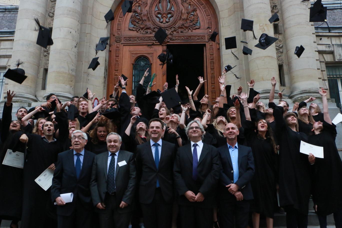 Le traditionnel lancer de chapeaux des diplômés sur le perron de la Maison de l’éducation permanente.