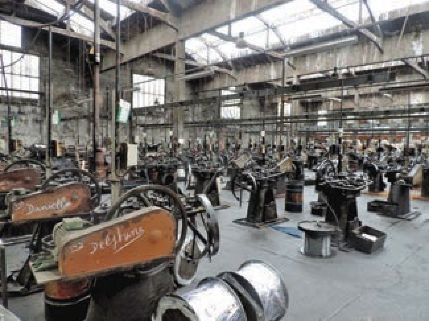 Trois ouvriers travaillent encore sur ces machines construites entre 1890 et 1925.