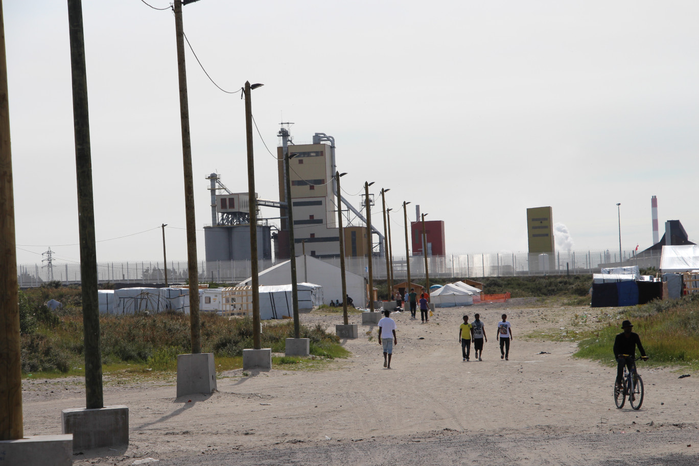 « Dans la lande aux abords de la zone portuaire, le camp des migrants jouxtent également la zone d'activités industrrielles des Dunes ».