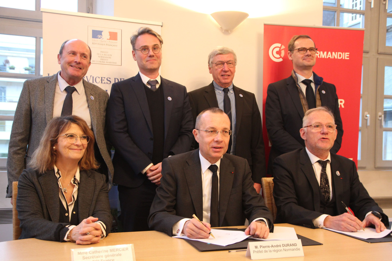 Crédit photo : BeDe pour Aletheia Press, « Catherine Mercier (CCI France) et Gilles Treuil (CCI Normandie) entourent le préfet de Normandie, sous le regard des présidents de 4 des CCI Territoriales de la région. ».