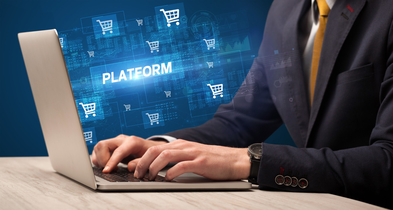 Businessman working on laptop with PLATFORM inscription, online shopping concept