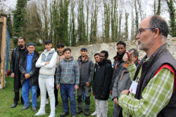 Philippe Haeyaert, encadrant de l&#039;Atelier de la Pierre, avec les personnes éloignées de l&#039;emploi qui interviendront dans la restauration du mur du verger, qui se trouve derrière eux. © V.K
